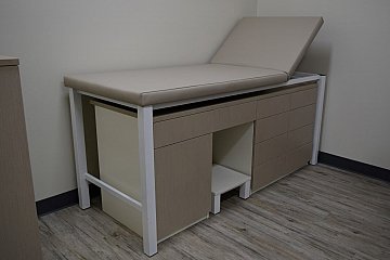 City Clinic, custom adjustable examination table with pull-out shelf, storage & step stool