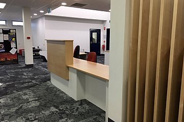 Mitcham Girls Library, Curved custom circulation desk in Young Beech/White 200 with internal acoustic panel