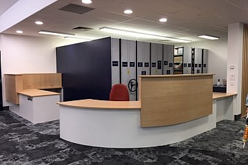 Mitcham Girls Library, Curved custom circulation desk in Young Beech/White 200 with internal acoustic panel